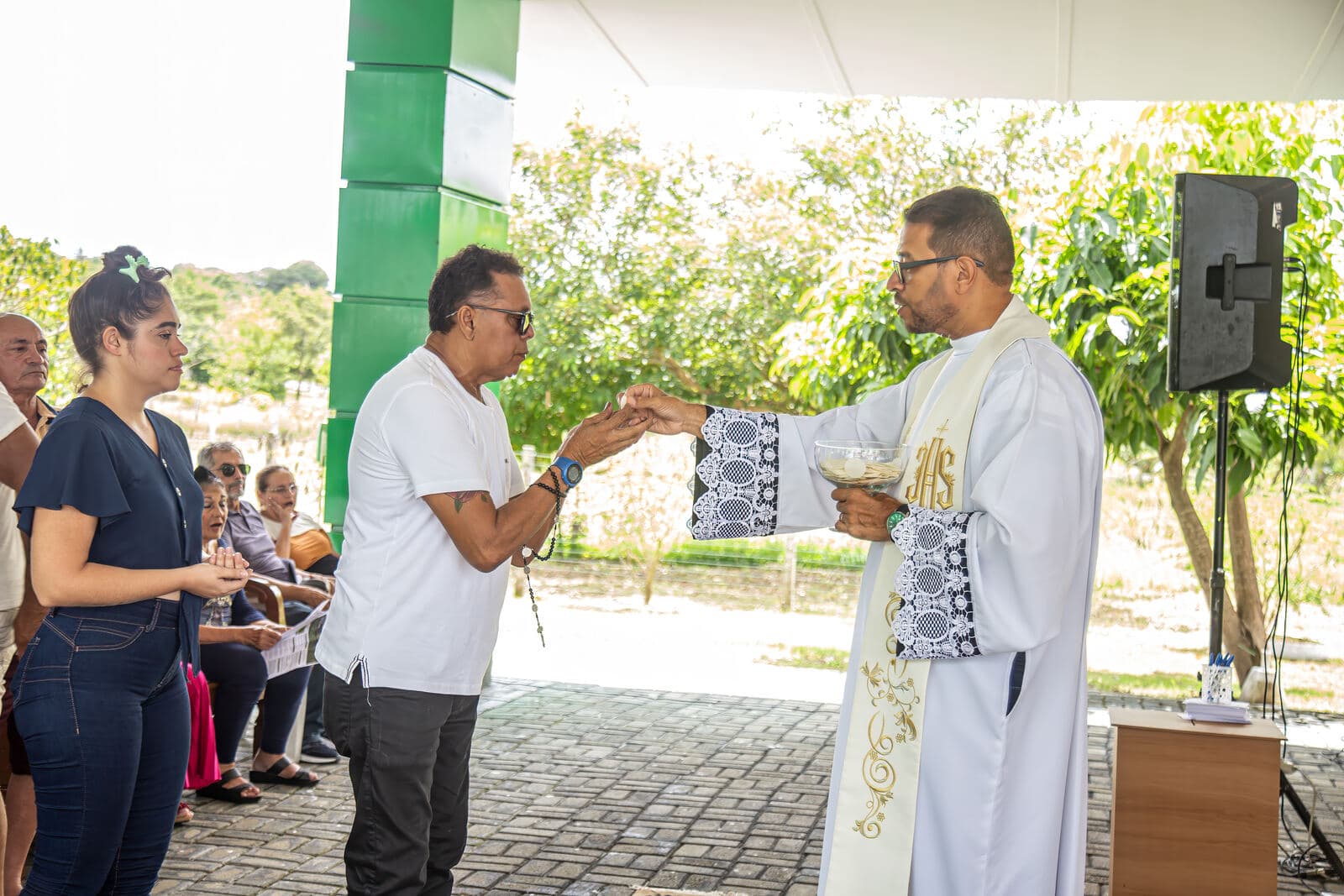 Padre abençoando as mães ao final da missa