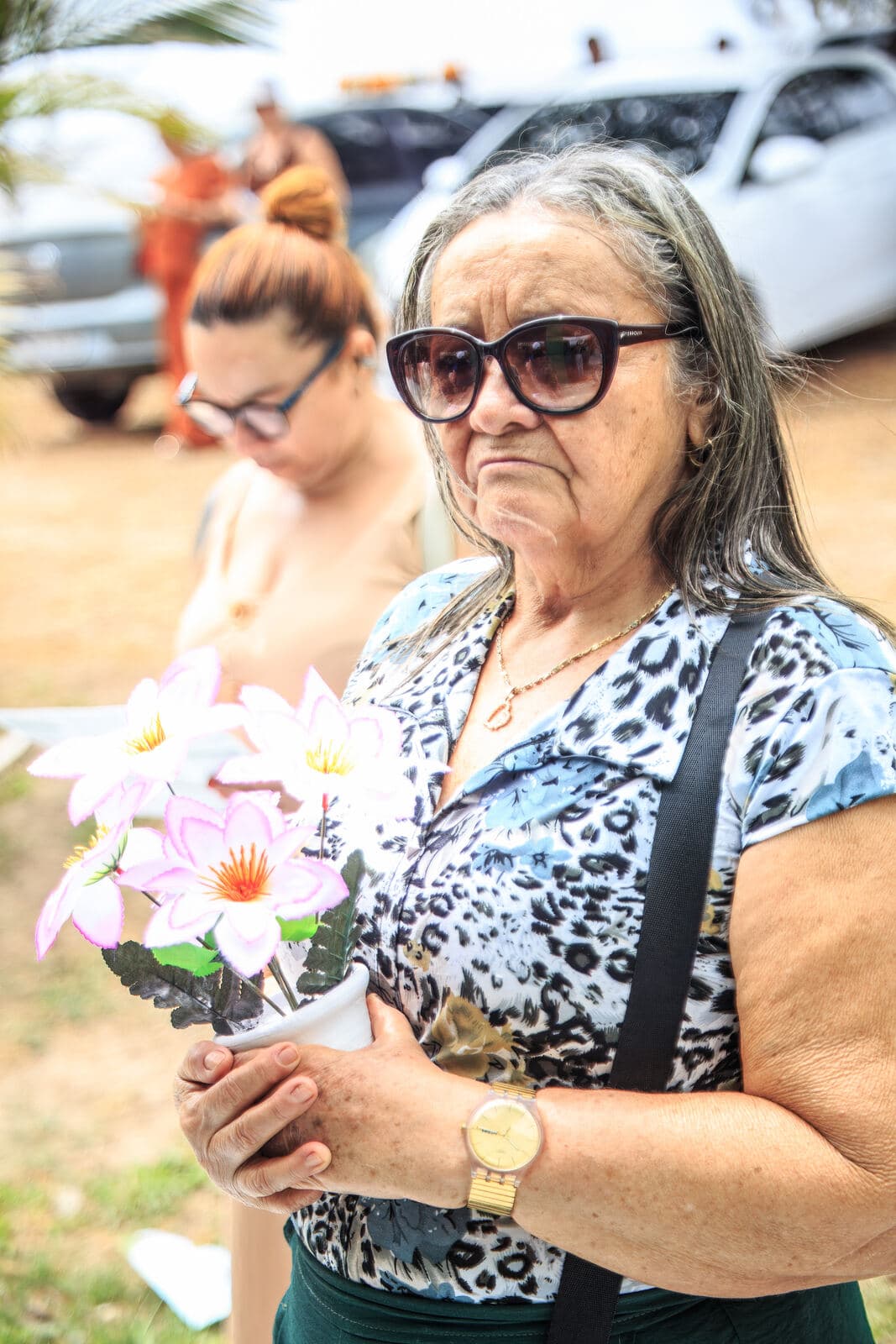 Senhora levando flores para homenagear seu ente querido
